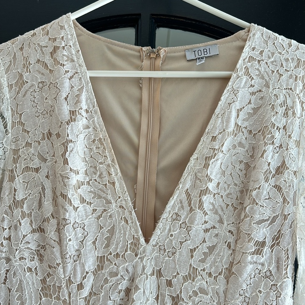 Tobi M white with crème underlay long sleeve zip up back. Cute flip skirt hem